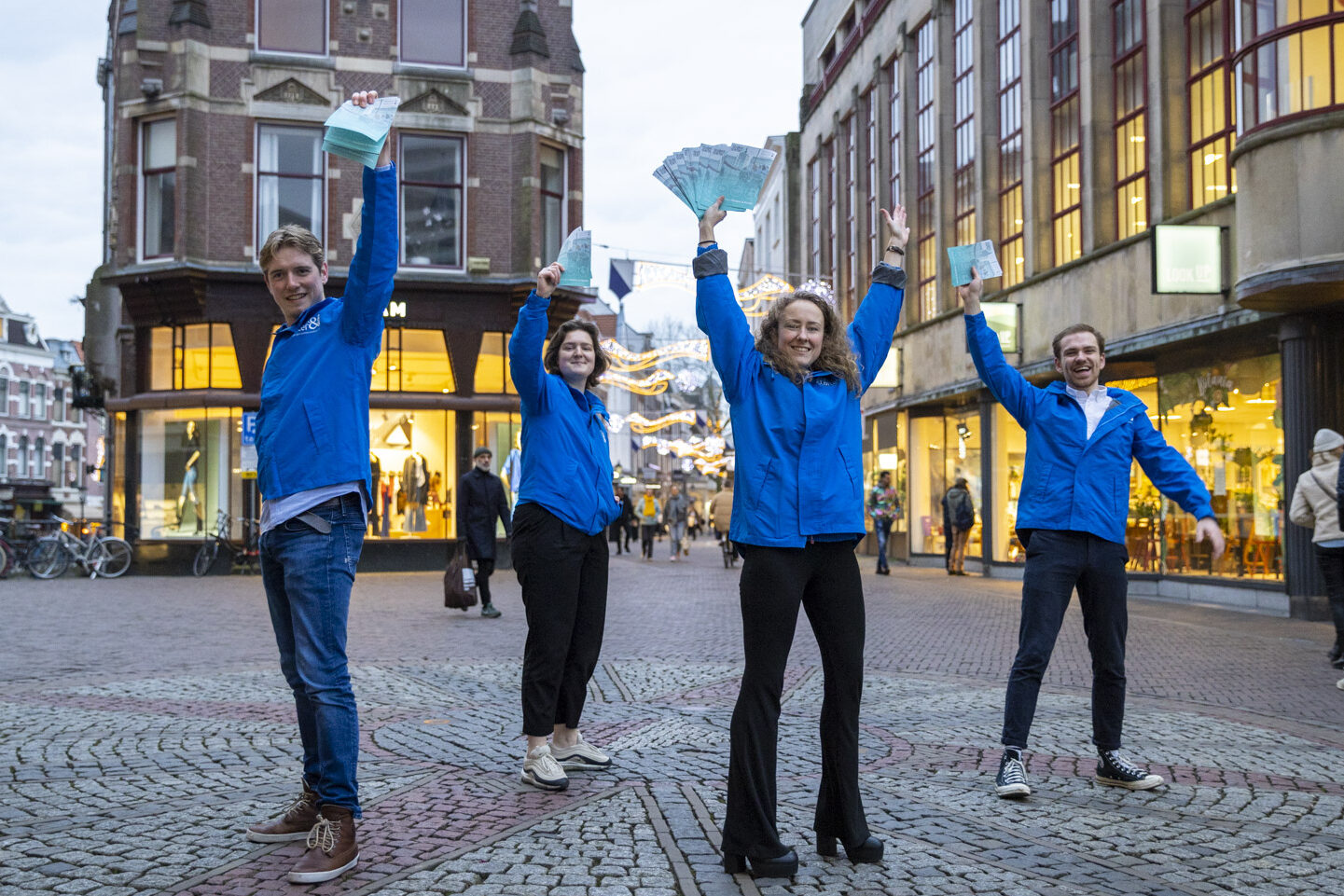 Vier kandidaten met flyers in hun handen die ze omhoog houden in Utrecht Centrum